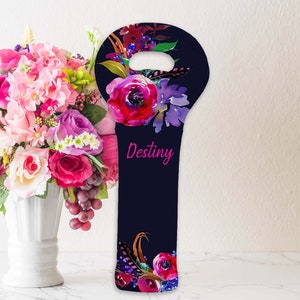 May include: A navy blue wine bottle bag with a floral design. The bag features watercolor flowers in shades of pink, purple, and red. The word "Destiny" is written in pink script. The bag has a handle at the top.