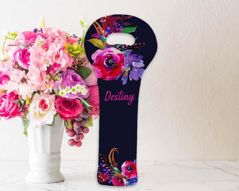 May include: A navy blue wine bottle bag with a floral design. The bag features watercolor flowers in shades of pink, purple, and red. The word "Destiny" is written in pink script. The bag has a handle at the top.