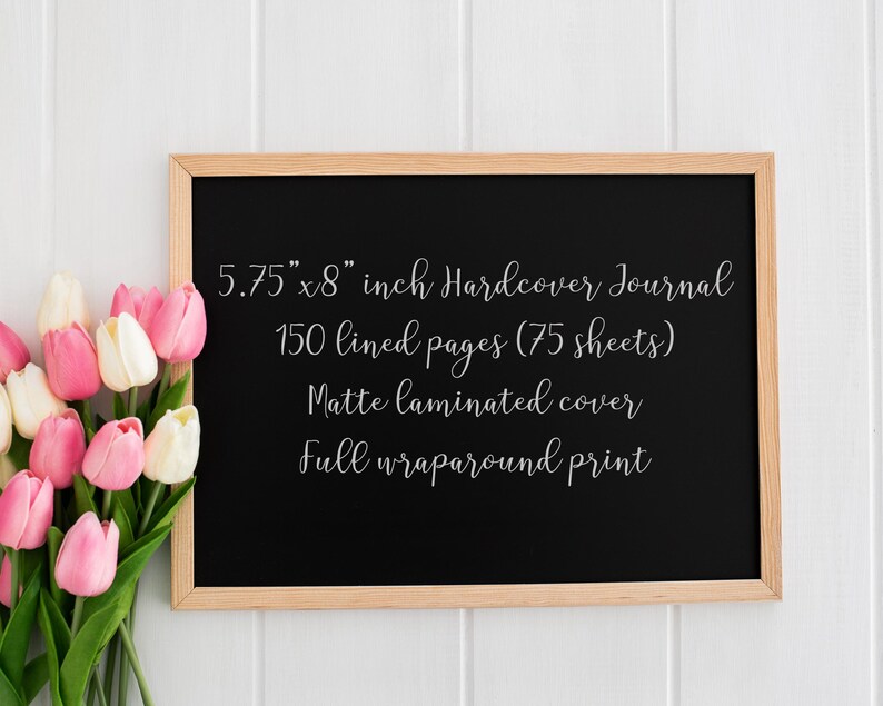 May include: A black hardcover journal with a wooden frame, measuring 5.75" x 8". The journal has 150 lined pages, a matte laminated cover, and a full wraparound print. A bouquet of pink and white tulips is in the lower left corner.