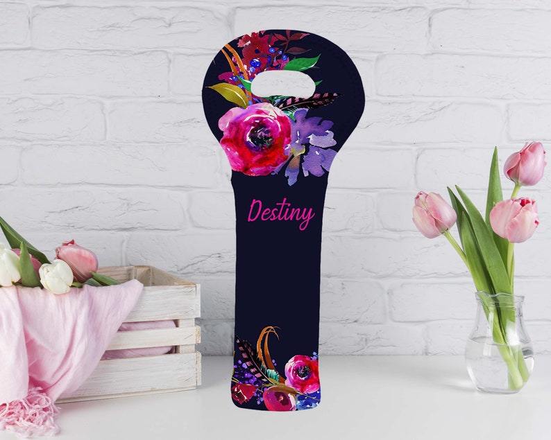May include: A navy blue wine bottle bag with a floral design. The bag features a large pink rose and other flowers in shades of red, purple, and yellow. The word "Destiny" is written in pink script.