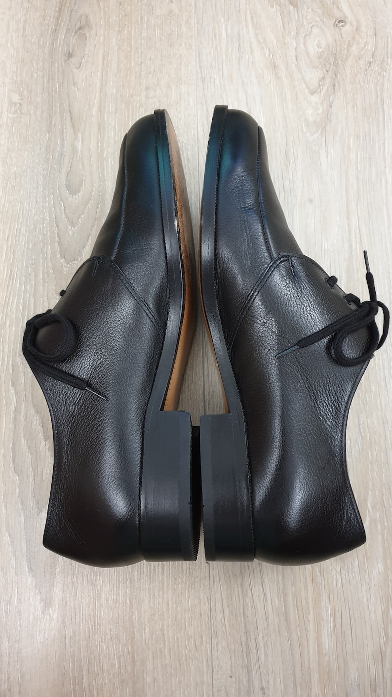 May include: A pair of black leather lace-up shoes with a rounded toe and a low heel.