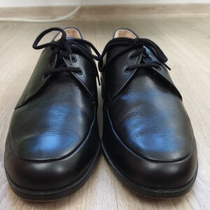 May include: A pair of black leather lace-up shoes with a rounded toe.