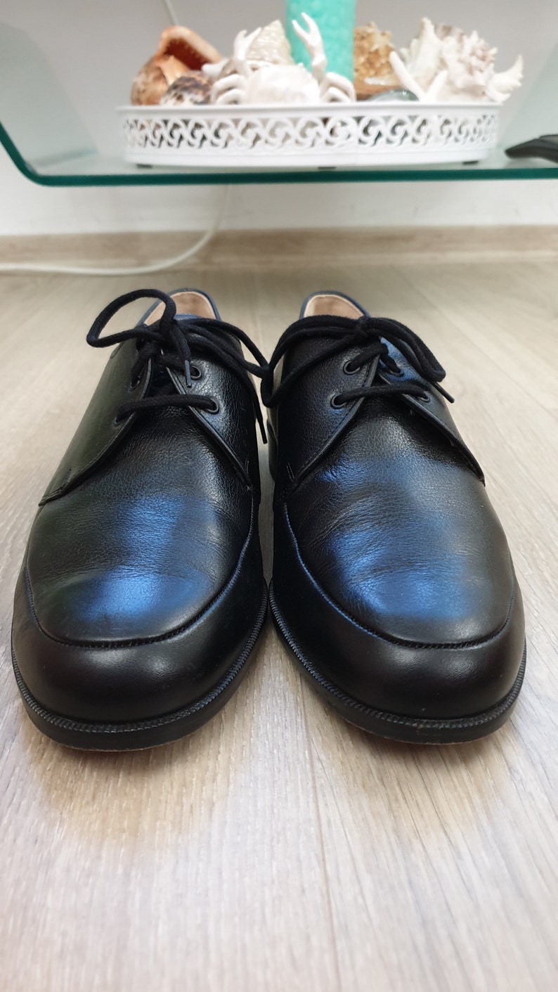 May include: A pair of black leather lace-up shoes with a rounded toe.