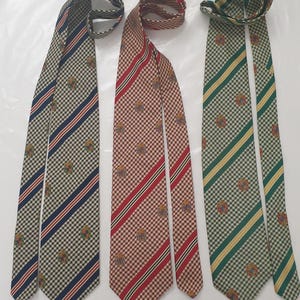 May include: Three neckties with distinct patterns and colors. One tie features a brown and red checkered pattern with red stripes, another has a green and yellow checkered pattern with yellow stripes, and the third has a blue and white checkered pattern with blue stripes.