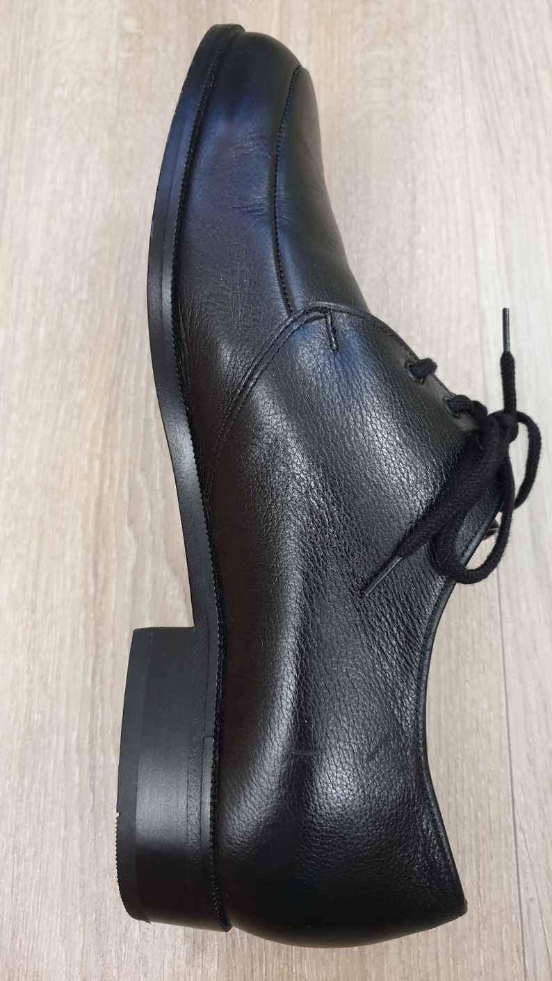 May include: A pair of black leather lace-up shoes with a rounded toe and a thick sole.