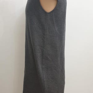 Puede incluir: Un vestido gris oscuro de manga corta. El vestido tiene una silueta simple y recta y un cuello redondo. La tela parece ser un material de punto suave. El vestido se exhibe en un maniqu&iacute;.