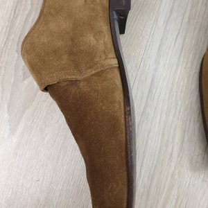 May include: A brown suede leather dress shoe with a black leather sole.