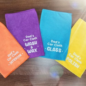 May include: Four microfiber cloths with different colored borders and text. The cloths are labeled "Dad's Car Cloth" with different uses: "Interior", "Wash & Wax", "Glass", and "Polish".