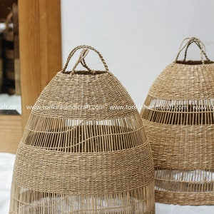 May include: Two natural woven wicker pendant light shades with a round shape and a woven pattern. The shades have a handle at the top.