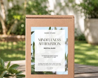 May include: A rectangular brown cardboard box featuring a white label with the text SAGEE STUDIO, MINDFULNESS AFFIRMATION, RESTFUL SLEEP, 52 WEEKS OF QUIET FOCUS, ONE CARD AT A TIME, and Display your week's focus where your eyes land often.