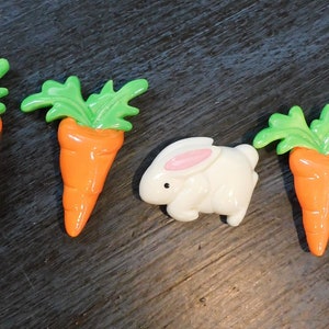 May include: Three green and orange carrot shaped decorations and a white rabbit shaped decoration.