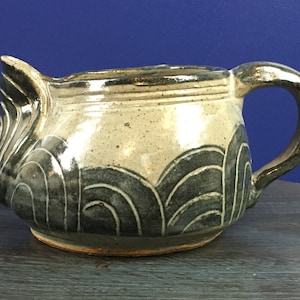 Unique, shallow, pottery pitcher with unknown signature