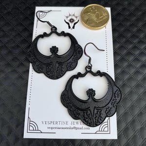 Pu&ograve; includere: Una tazza di ceramica bianca con manico nero e la scritta "But First, Coffee" in grassetto nero. La tazza &egrave; posta su uno sfondo sfocato, suggerendo un'atmosfera accogliente.