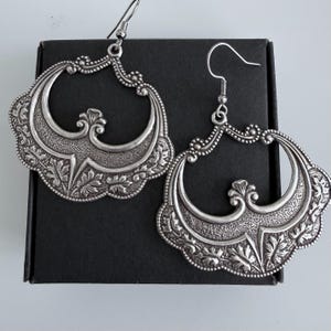 Pu&ograve; includere: Un set di tre tazze in ceramica con finitura opaca e macchiettata. Le tazze sono nei toni del crema, grigio chiaro e grigio scuro. Ogni tazza ha un design semplice e minimalista.