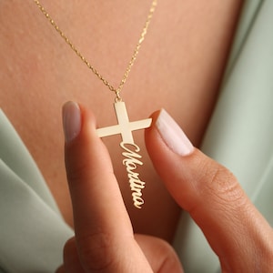 May include: Gold necklace with a cross pendant featuring the name "Martina" engraved on it.