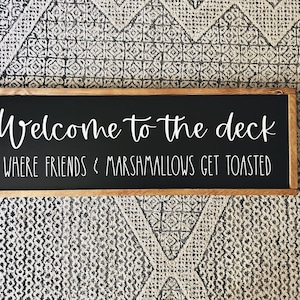 Peut inclure: Une pancarte en bois avec de la peinture noire pour tableau noir et une inscription blanche qui dit "Bienvenue sur la terrasse où les amis et les guimauves sont grillés".