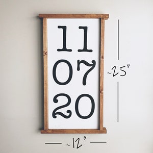 K&ouml;nnte beinhalten: Ein Schild mit Holzrahmen und der Aufschrift "11 07 20" in schwarzen Buchstaben. Das Schild ist etwa 30,5 cm breit und 63,5 cm hoch.
