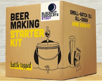 May include: A brown cardboard box with a black and white illustration of a beer making kit. The box has the text "BEER MAKING STARTER KIT" and "Blackout Chocolate Stout" on it. The kit includes a 5L all-grain home brew kit.