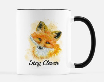 May include: White ceramic mug with a black handle. The mug features a watercolour illustration of a fox with the text "Stay Clever" printed below the image.