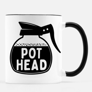 Może przedstawiać: Biały ceramiczny kubek do kawy z czarnym rantem i uchwytem. Kubek przedstawia czarno-białą ilustrację dzbanka do kawy z napisem "POT HEAD" z przodu.
