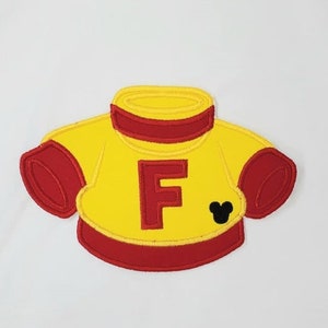 May include: Yellow and red embroidered iron-on patch of a sweater with a letter F and a Mickey Mouse head.