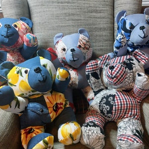 Puede incluir: Cinco osos de peluche patchwork hechos de diferentes telas, incluyendo denim, estampados florales y cuadros, están sentados en un sofá gris. Los osos son todos de diferentes colores y tienen diferentes expresiones faciales.