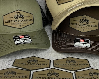 Peut inclure: Un ensemble de casquettes de camionneur brunes, vertes et beiges avec des panneaux arrière en maille noire. Chaque casquette est ornée d'un écusson brodé personnalisé avec un motif de tracteur et du texte qui dit "Custom Farm Hats" et "Personalized Text". Les casquettes sont exposées sur une surface blanche avec plusieurs autocollants hexagonaux représentant des motifs de tracteurs et du texte tel que "Fairlane Dairy", "Miller Family Farm", "Johnson Farms", "Douglas Tractor", "Baker Ranch" et "Turner Ranch".