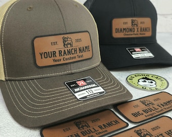 May include: Two trucker hats, one brown and one black, with leather patches. The brown hat has "YOUR RANCH NAME" and "Your Custom Text" on the patch. The black hat says "DIAMOND X RANCH". Additional patches are visible.