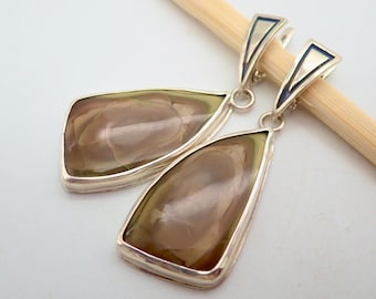 May include: A pair of silver dangle earrings with a teardrop-shaped brown and green gemstone. The earrings have a silver hook closure.