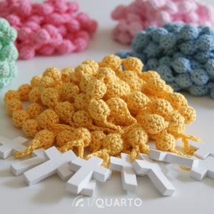 May include: Four sets of crocheted beads with wooden crosses. The beads are in shades of green, pink, blue, and yellow.