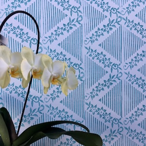 Puede incluir: Una planta de orquídea blanca con flores amarillas en flor sobre un fondo estampado azul y blanco.