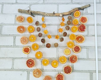 Guirnalda de cítricos en una rama de madera, decoración interior y exterior.