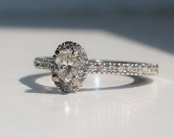 Anillo de compromiso con diamante ovalado de 1,00 ct, color D, claridad SI1, certificado por GIA, con halo de micro pavé en oro de 14 quilates.