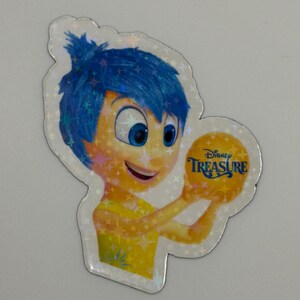 May include: A holographic sticker featuring the character Joy from the Disney movie Inside Out. Joy has blue hair and a yellow dress, holding a golden ball with the text "Disney Treasure". The sticker has a sparkly, iridescent finish.