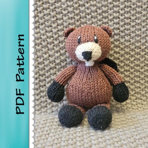 以下が含まれることがあります： 黒い目と白い鼻を持つ、茶色のニット生地でできたビーバーのぬいぐるみ。ぬいぐるみは茶色のニット生地の表面に座っています。