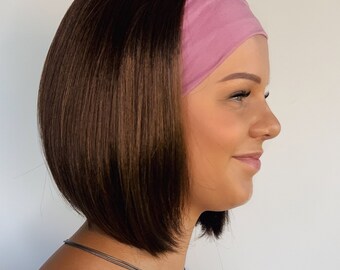 May include: A woman with shoulder-length brown hair wearing a pink headband. She is wearing a white vest top and a silver necklace.
