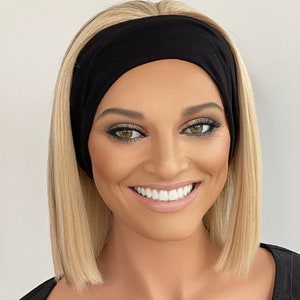 May include: A woman with blonde hair is wearing a black headband. The headband is made of a soft, stretchy fabric.