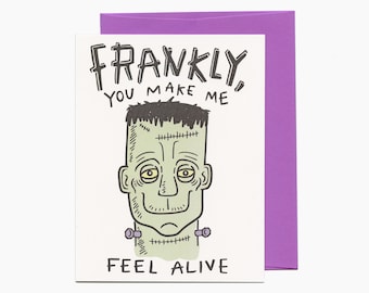 May include: A white card with a green Frankenstein-like monster illustration. The card says "Frankly, you make me feel alive." at the top and "@lucky sardine" at the bottom.