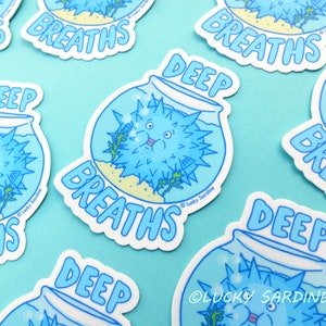 May include: Five colorful stickers with a cartoon blue pufferfish in a fishbowl. The stickers say "Deep Breaths" in a blue font. The stickers are on a light blue background.
