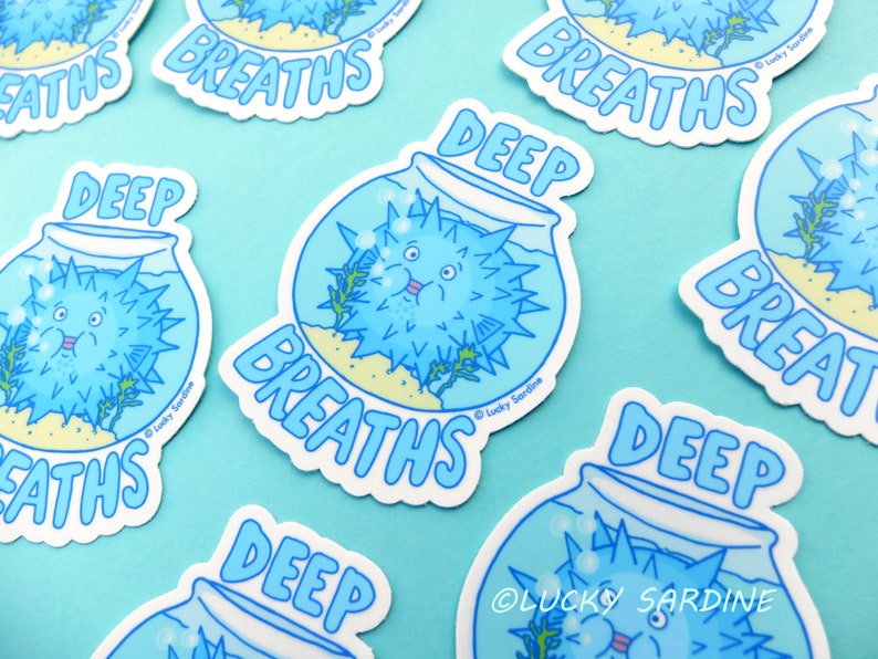 May include: Five colorful stickers with a cartoon blue pufferfish in a fishbowl. The stickers say "Deep Breaths" in a blue font. The stickers are on a light blue background.