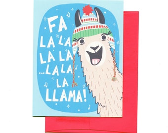 May include: A blue Christmas card with a llama wearing a red and green striped hat with a pom-pom on top. The llama is singing "Fa la la la la... la la llama!"