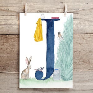 May include: A watercolor illustration of the letter J in navy blue with a yellow raincoat, a red book, a small bird, a rabbit, a toy airplane, and a water bottle on a white background.