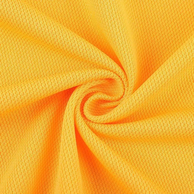 May include: Close-up of a vibrant yellow fabric with a textured, honeycomb-like pattern. The material is tightly woven and appears to be a lightweight, breathable textile, possibly for sportswear or summer apparel. The fabric is swirled, creating a spiral effect.