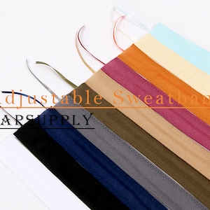 May include: A set of ten adjustable sweatbands in various colours, including black, navy blue, grey, olive green, beige, brown, burgundy, orange, light yellow, and light blue. The sweatbands are made of a soft, stretchy fabric and are designed to be comfortable and absorbent. The text "Adjustable Sweatband" and "CARSUPPLY" is visible in the image.