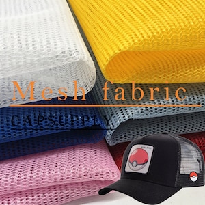 May include: A range of colours of mesh fabric, including white, yellow, grey, blue, pink, and red. The fabric is used for making caps. The text "Mesh fabric" and "CAP SUPPLY" is visible on the fabric. A black baseball cap with a red and white Pokeball graphic is in the foreground.