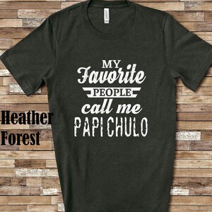 May include: Dark grey t-shirt with white text that reads "My Favourite People Call Me Papi Chulo".