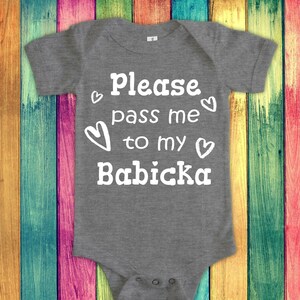Puede incluir: Mono de bebé gris con texto blanco que dice "Por favor, pásame a mi Babicka" con corazones alrededor del texto.
