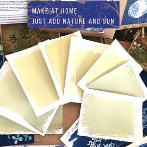 May include: A close-up of seven cyanotype prints, each with a different shade of blue, arranged in a fan shape. The prints are on white paper with a white border. The text "MAKE AT HOME JUST ADD NATURE AND SUN" is visible in the top centre of the image.
