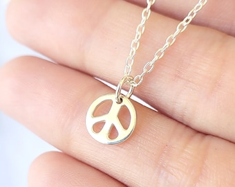 May include: A silver chain necklace with a peace sign pendant.