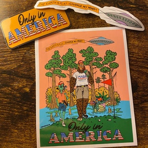 May include: A sticker with a cartoon illustration of a Bigfoot playing golf with an alien in a swamp. The sticker has the text "Only in America" and "The Earth is Flat: Change My Mind!" with a UFO flying overhead.